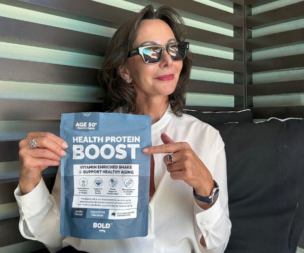 Woman holding a pouch of BOLD Health Protein Boost while travelling