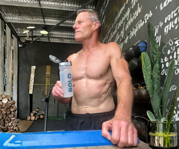 Athletic man holding a BOLD shaker after training