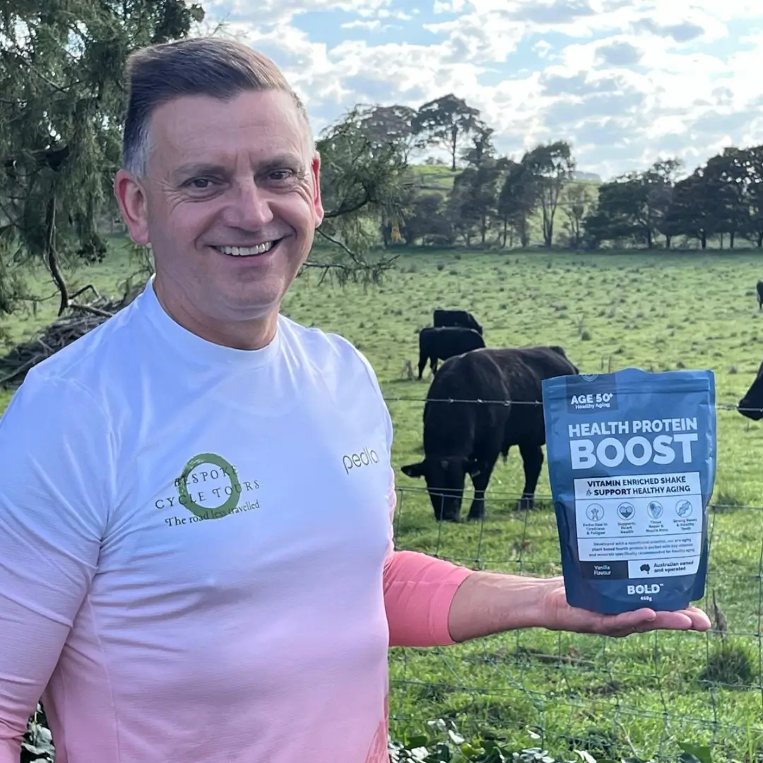 Customer in field with cows holding Health Protein Boost